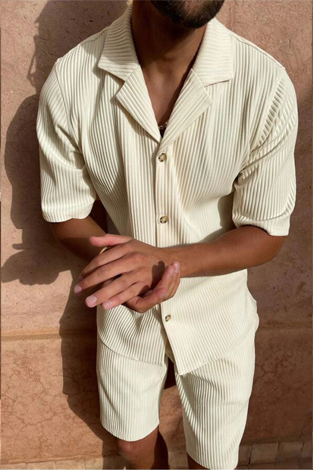 Model wearing a men's relaxed fit textured short-sleeve shirt & matching shorts summer outfit set. Casual style.