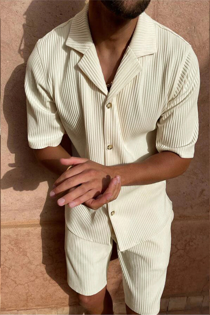 Model wearing a men's relaxed fit textured short-sleeve shirt & matching shorts summer outfit set. Casual style.