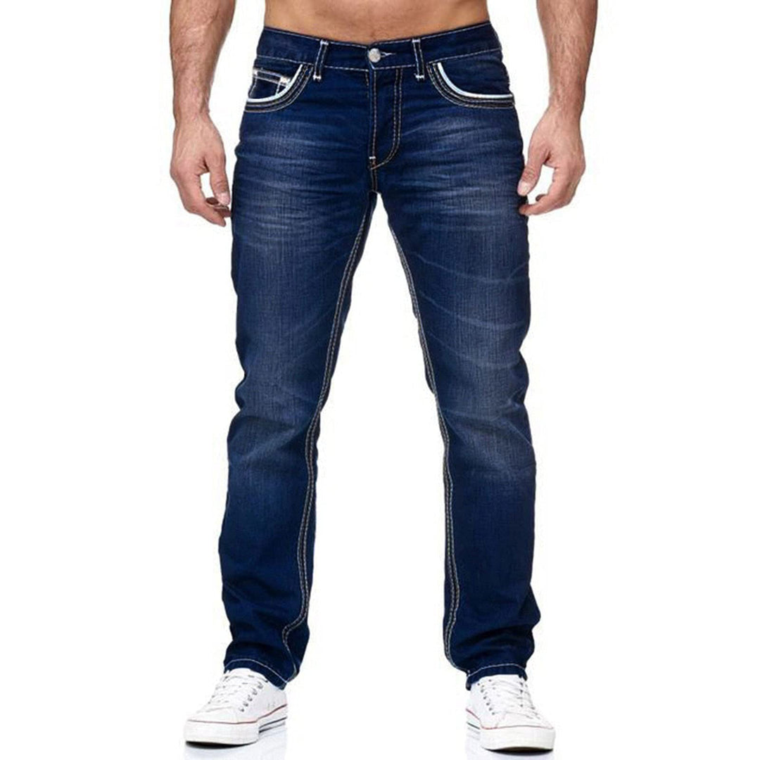 Close-up of men's slim fit jeans, showcasing used-style wash and distinct contrast stitching detail.