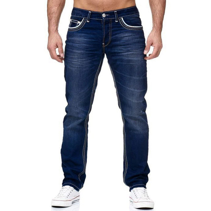 Close-up of men's slim fit jeans, showcasing used-style wash and distinct contrast stitching detail.
