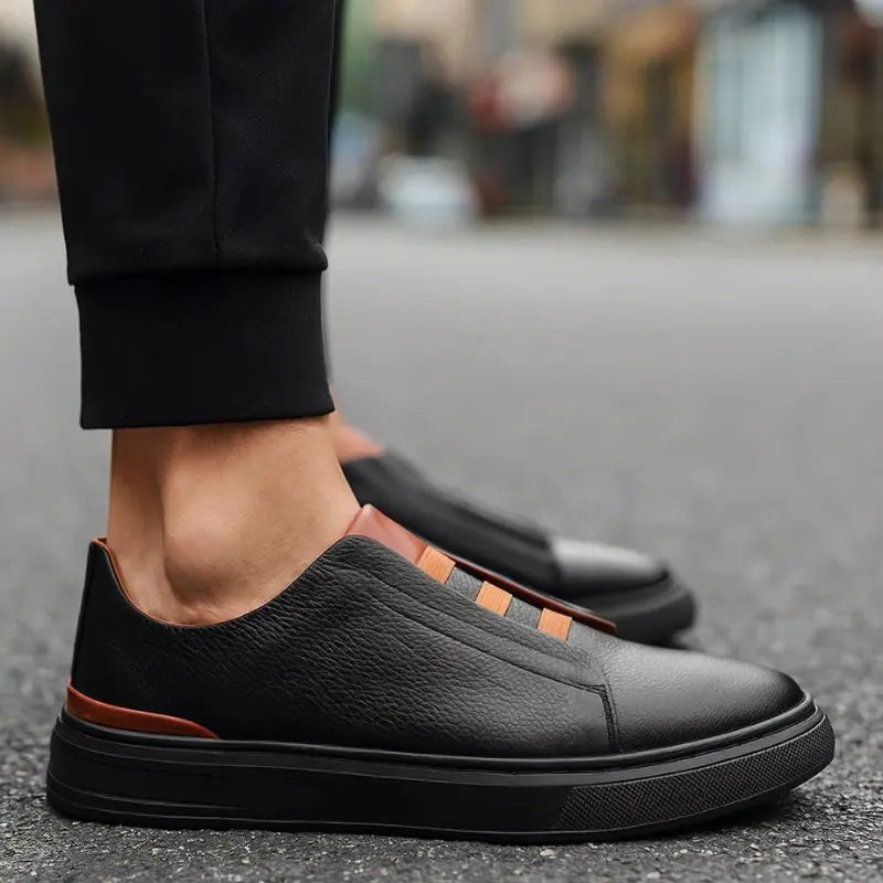 Close-up of men's slip-on trainers with distinctive loop lacing, offering modern athletic footwear style.