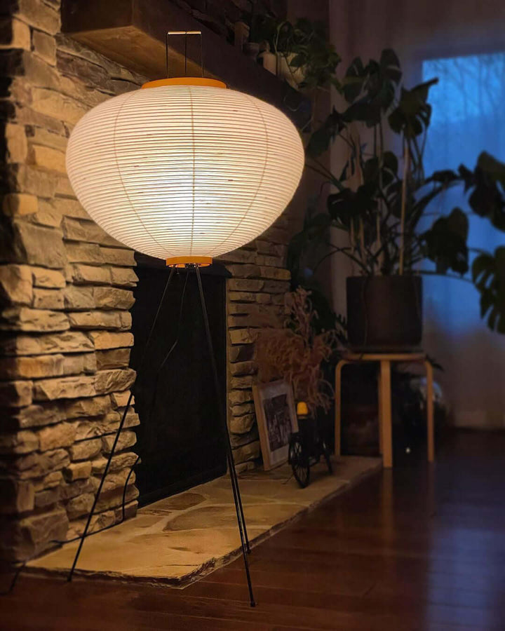 "Minimalist rice paper floor lamp with sleek metal frame and soft diffused light, perfect for creating a warm ambiance."