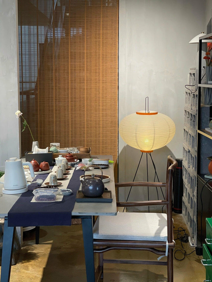 "Minimalist rice paper floor lamp with sleek metal frame and soft diffused light, perfect for creating a warm ambiance."