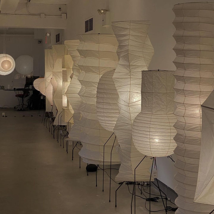 "Minimalist rice paper floor lamp with sleek metal frame and soft diffused light, perfect for creating a warm ambiance."