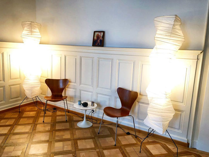 "Minimalist rice paper floor lamp with sleek metal frame and soft diffused light, perfect for creating a warm ambiance."