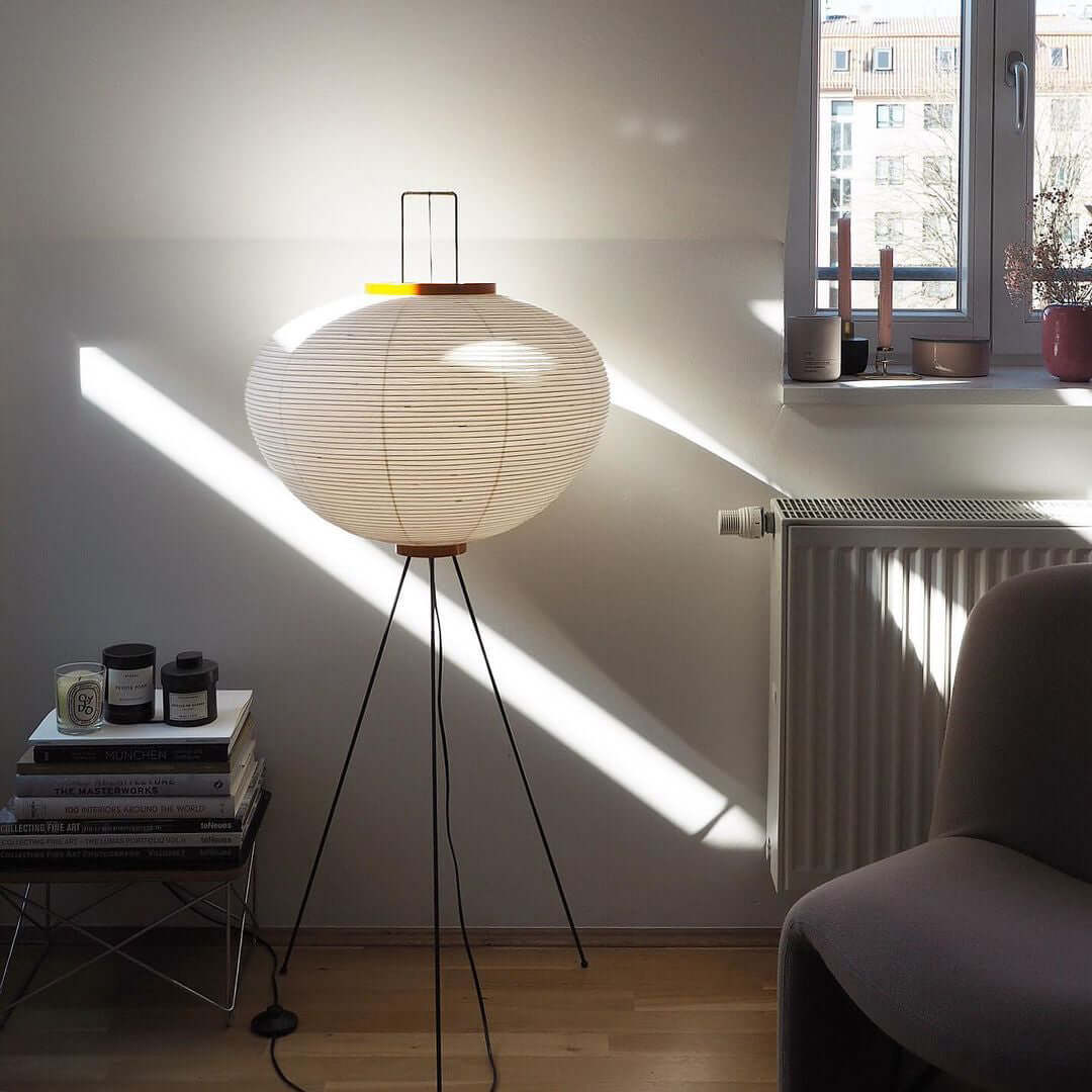 "Minimalist rice paper floor lamp with sleek metal frame and soft diffused light, perfect for creating a warm ambiance."