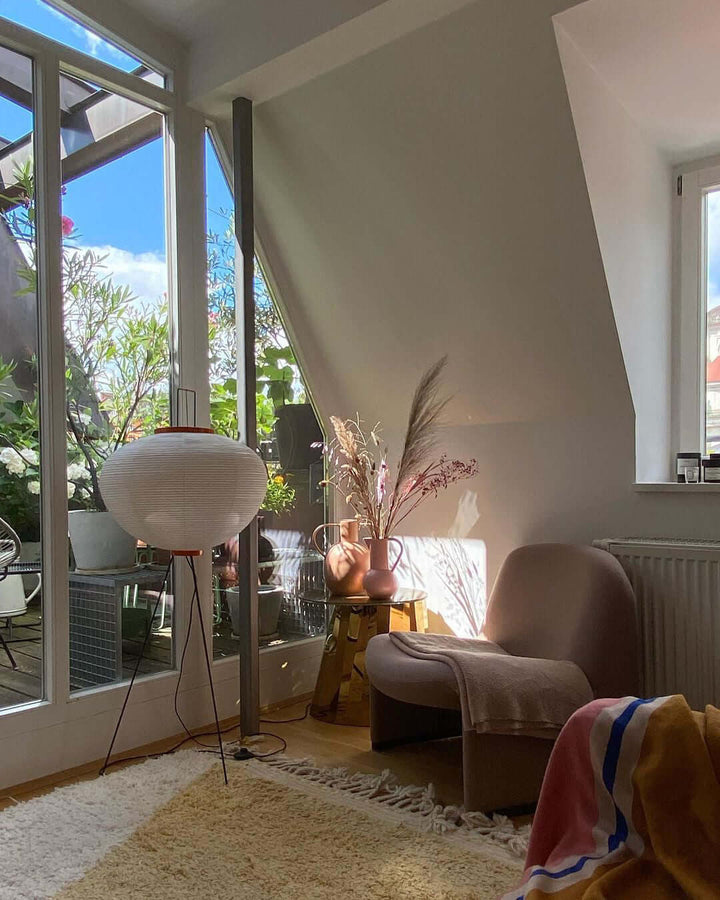 "Minimalist rice paper floor lamp with sleek metal frame and soft diffused light, perfect for creating a warm ambiance."