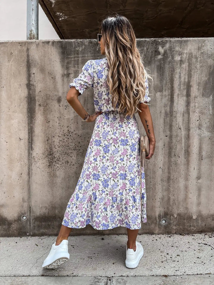 Women's elegant floral print summer dress twirling, showcasing flowy, breathable design, ideal vacation.