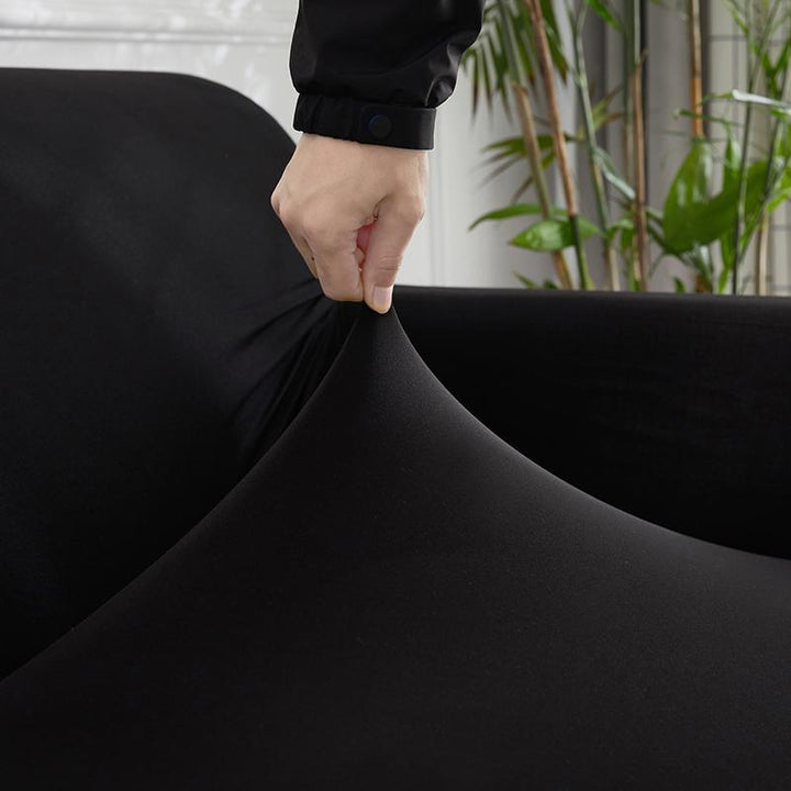 "Noir stretchable sofa cover in solid color, showcasing sleek fit and elegant style for versatile home decoration."