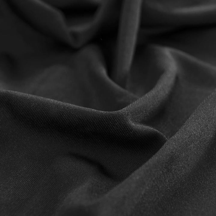 "Noir stretchable sofa cover in solid color, showcasing sleek fit and elegant style for versatile home decoration."