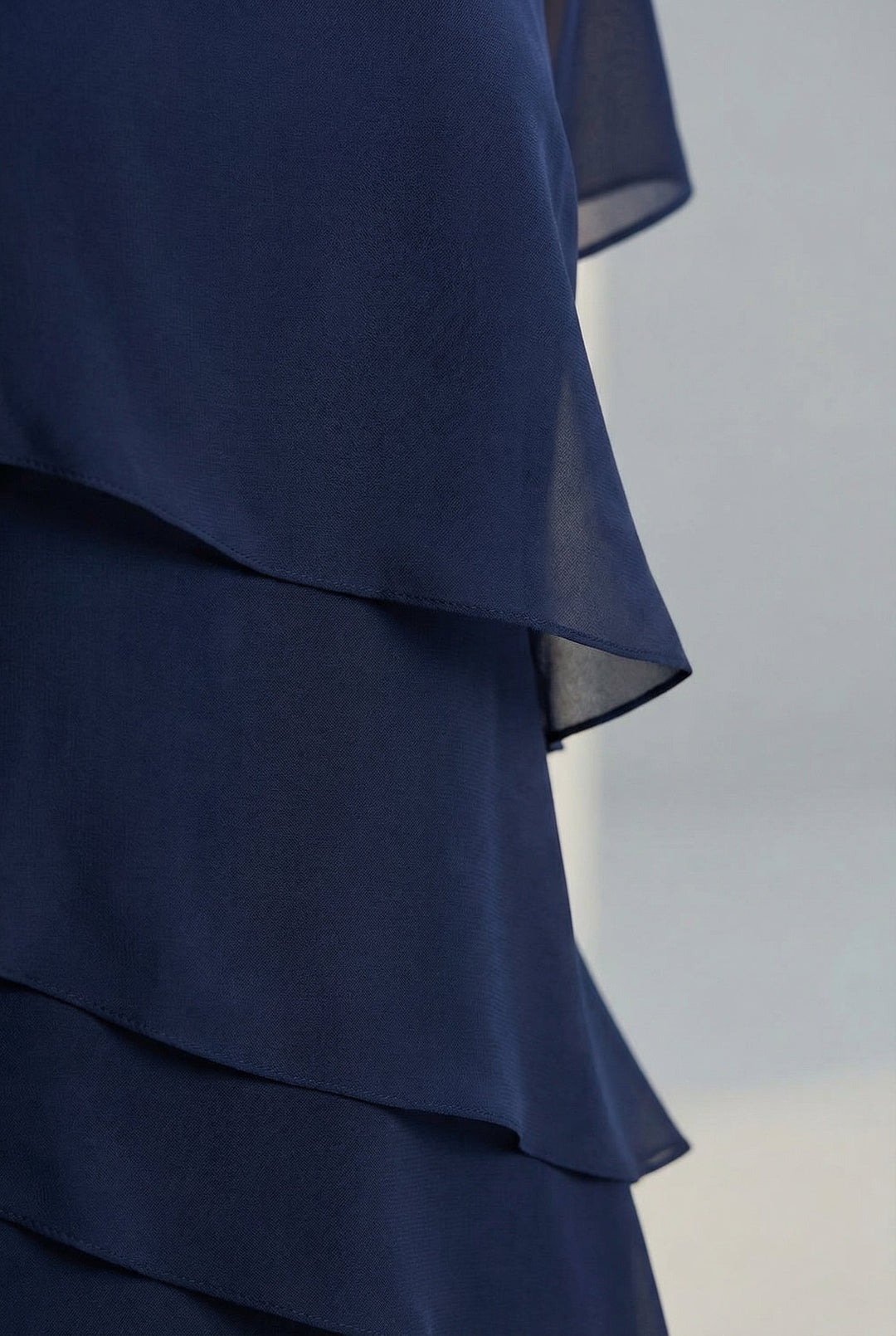 Women's elegant midi dress featuring ruffles, flowing fabric, and sheer sleeves for a feminine spring look.