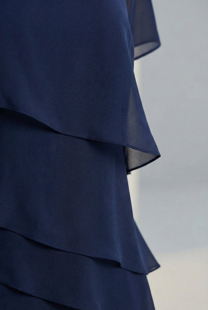 Women's elegant midi dress featuring ruffles, flowing fabric, and sheer sleeves for a feminine spring look.