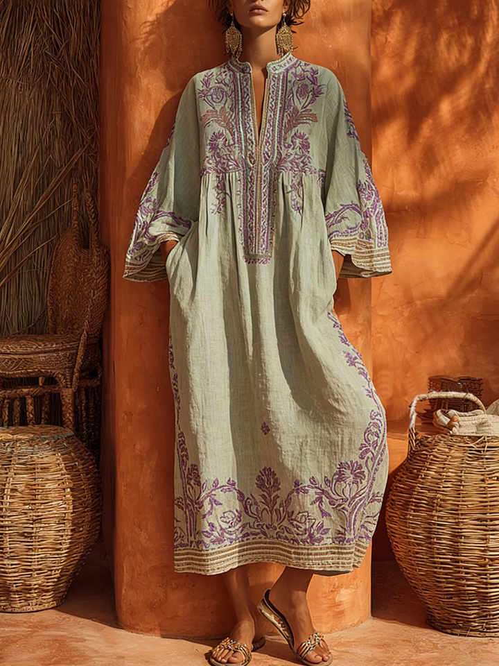 Women's long embroidered maxi dress with V-neck & bell sleeves, ideal for a relaxed summer vacation outfit.
