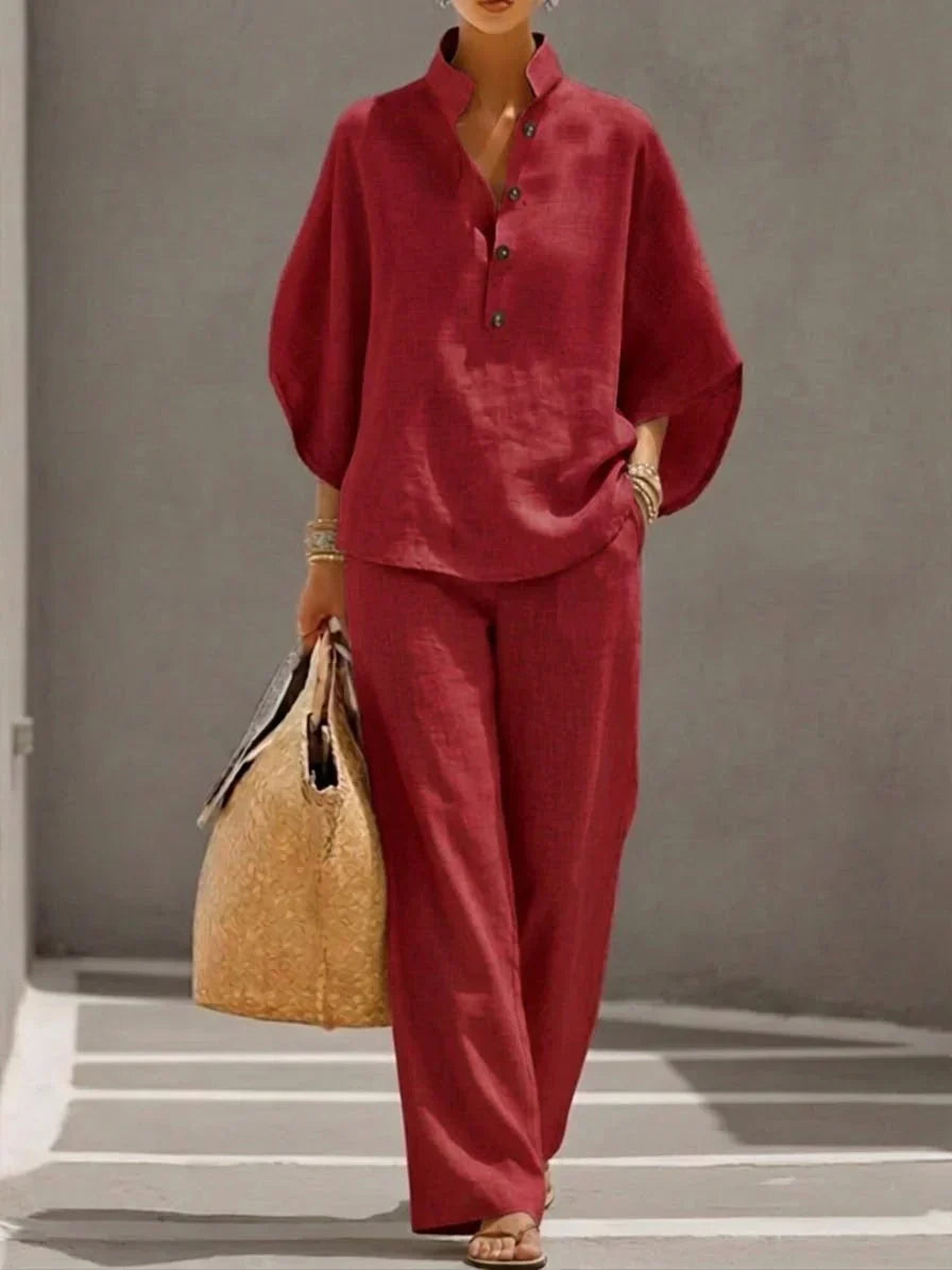 Model wearing a casual women's linen set. Batwing top & wide leg trousers in a neutral color.