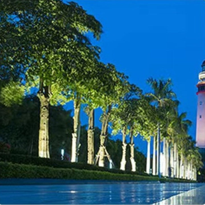 "Outdoor LED spotlights softly lighting tree bases with warm white glow, enhancing garden aesthetics with elegant aluminum de