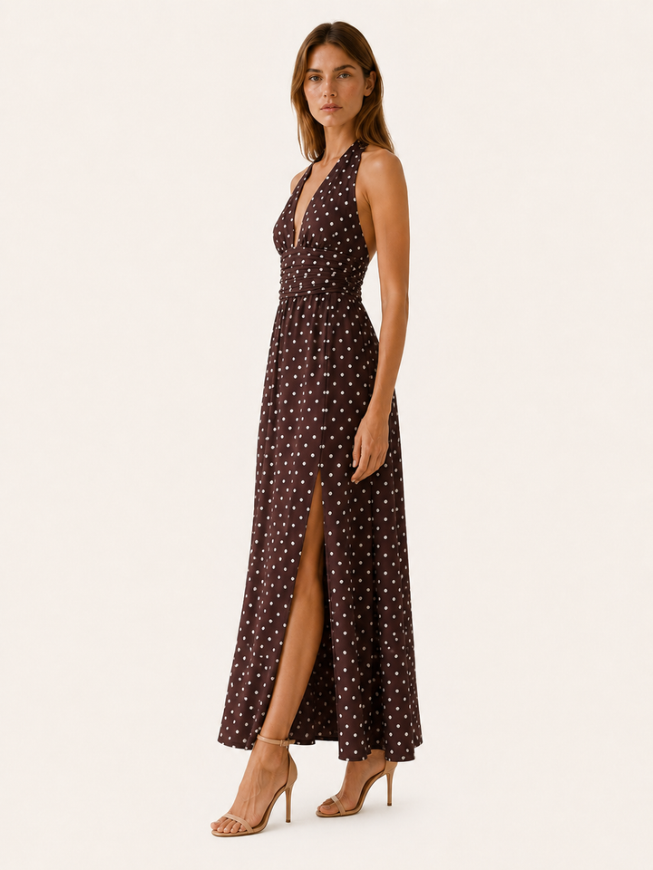 Flowy women's polka dot maxi dress featuring a stylish halter neck. Elegant design for summer events & evening wear.