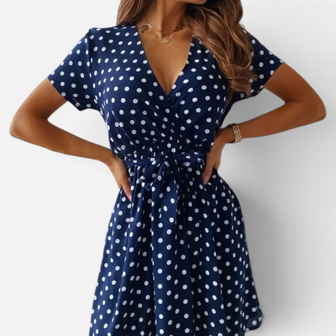 Stylish women's polka dot wrap mini dress. Short sleeve V-neck, flattering silhouette. Ideal for smart casual & everyday.
