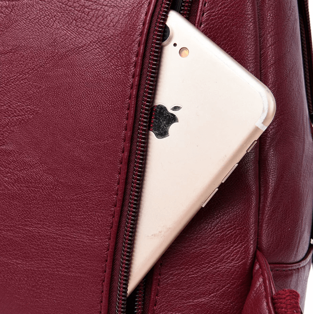 Woman wearing a stylish water-resistant leather shoulder backpack. Perfect for a fashion-forward look.
