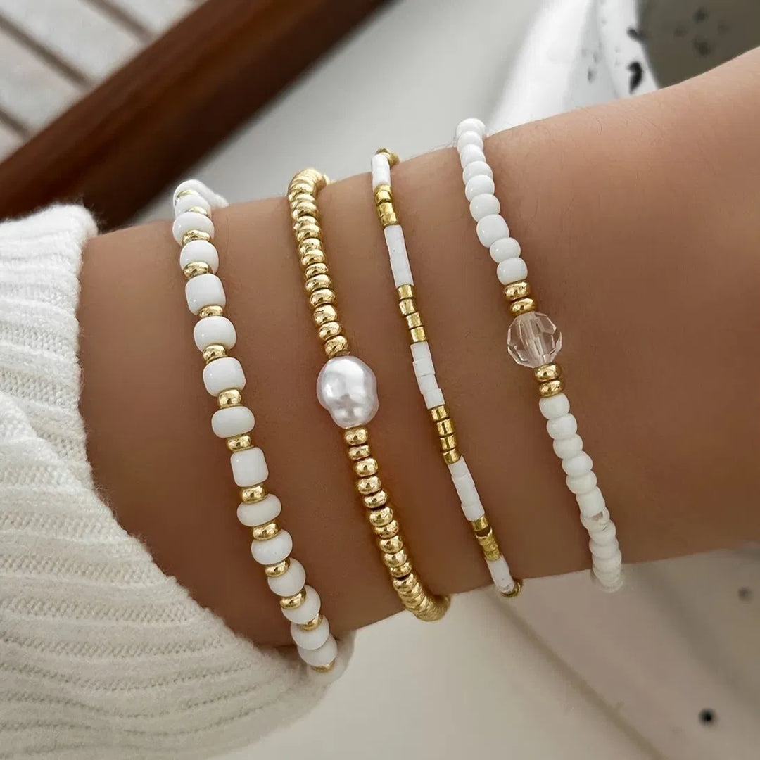 Elegant Women's Gold Pearl Accent Bracelet Set of 4. Featuring stackable delicate gold chains & lustrous pearls.