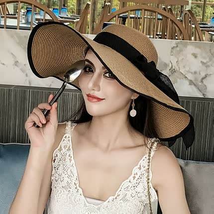 Fashionable women's straw sun hat with a wide brim and cute bow, a must-have summer accessory.
