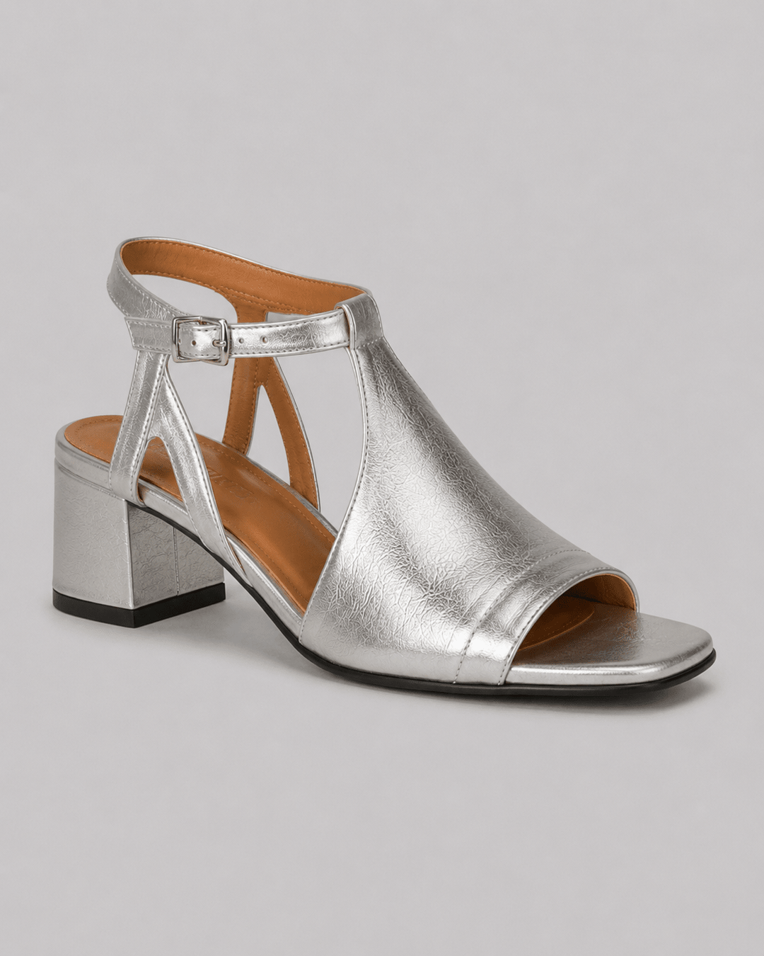 Women's silver shimmering block heel sandals with comfortable cross straps, ideal for summer events.