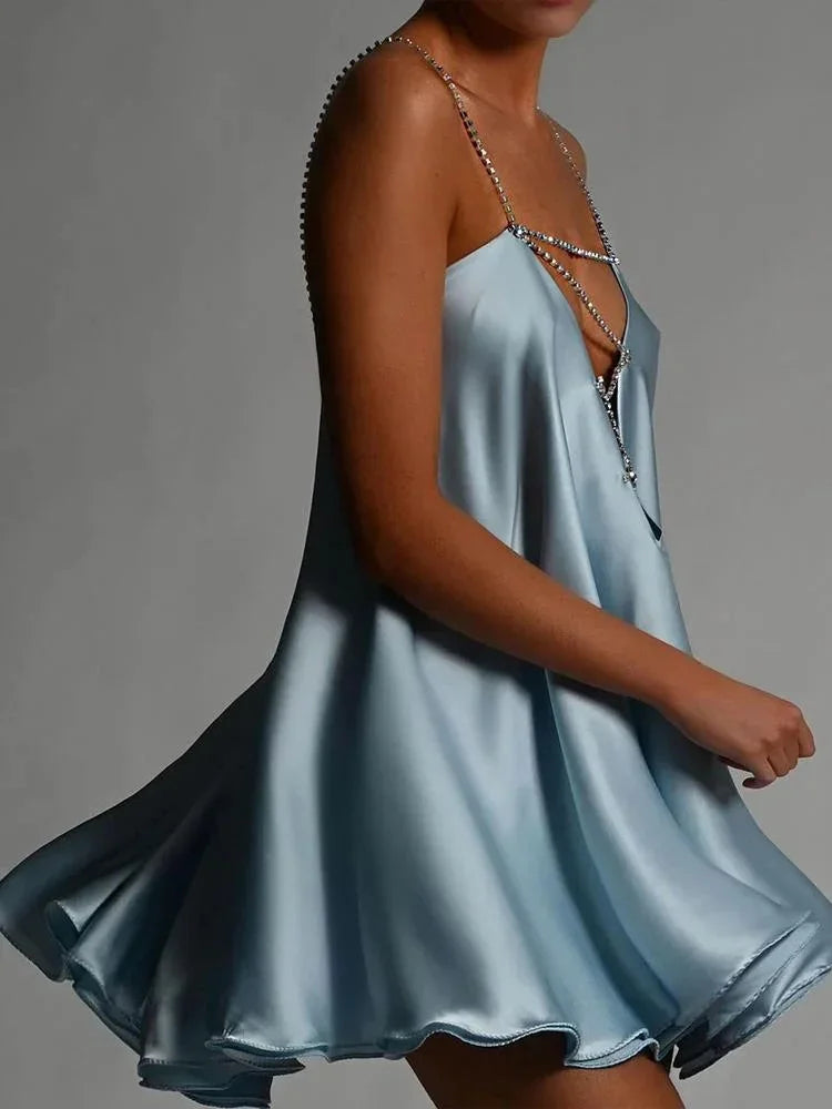 Stylish women's special occasion mini dress; sparkling fabric, backless design, and chic chain straps.