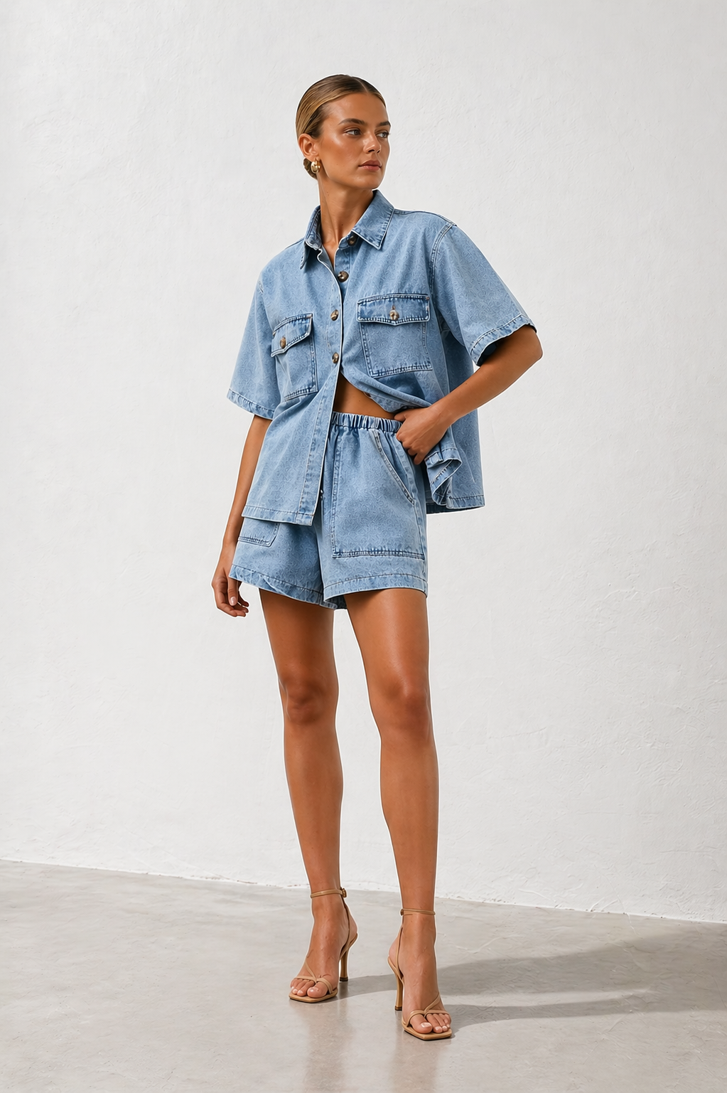 Fashionable women's denim two-piece: a classic button-down shirt & stylish high-rise shorts for a modern look.