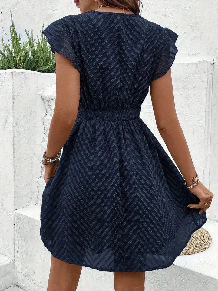 Stylish white flutter sleeve V-neck mini dress, a flared design perfect for elegant party wear.