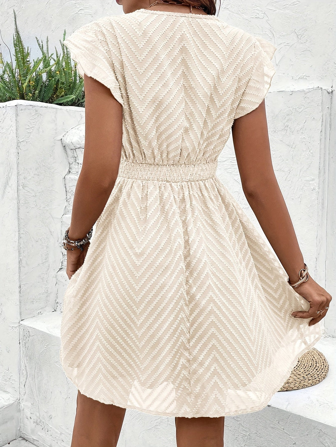 Elegant women's mini dress: V-neck, flutter sleeves, and flared skirt. Available in apricot.