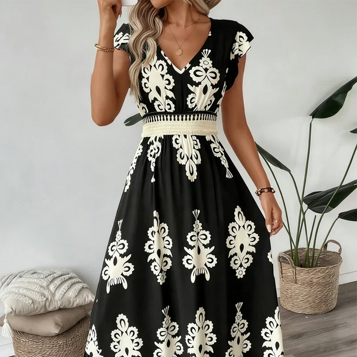 Back view of an elegant women's embroidered summer midi dress, showing flared hem detail.