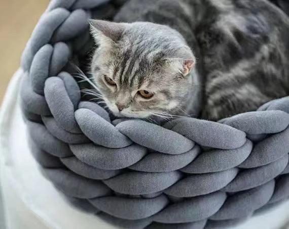 Knitted cat bed, a stylish and cozy feline furniture piece. Handmade pet accessory for ultimate cat comfort.