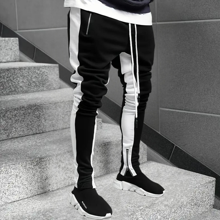 Stylish men's slim fit joggers featuring trendy contrast panels & practical zip cuffs. Modern activewear fashion.