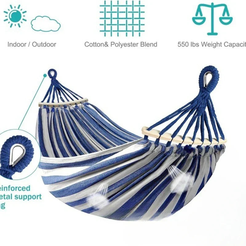 Portable double canvas hammock with wooden bars, ideal for camping, beach, or patio.