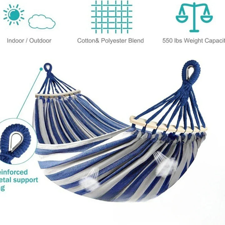 Portable double canvas hammock with wooden bars, ideal for camping, beach, or patio.