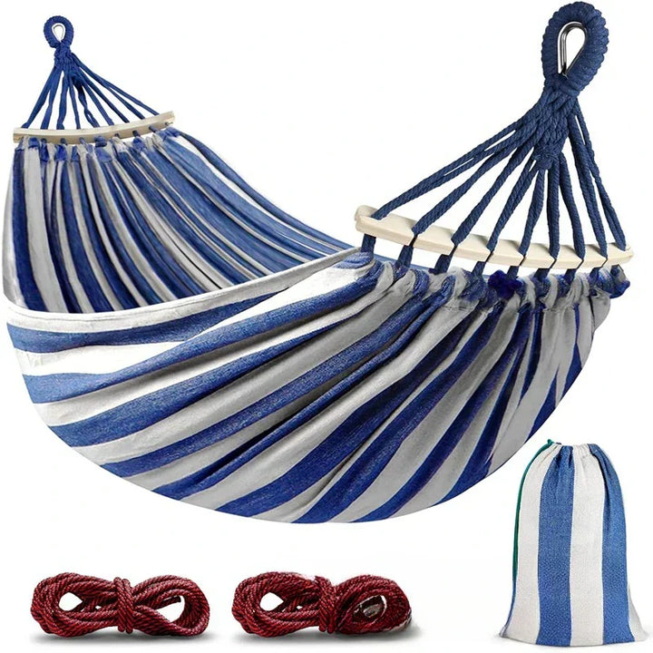 Outdoor double canvas hammock with robust wooden spreader bars for ultimate relaxation.