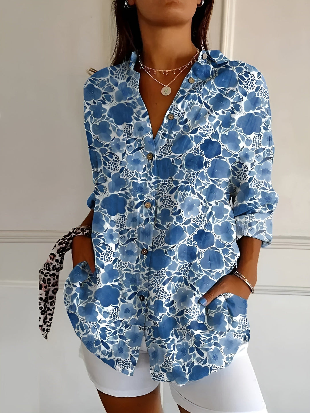 Women's printed button-front blouse with rolled 3/4 sleeves. Chic patterned top for spring/summer fashion.
