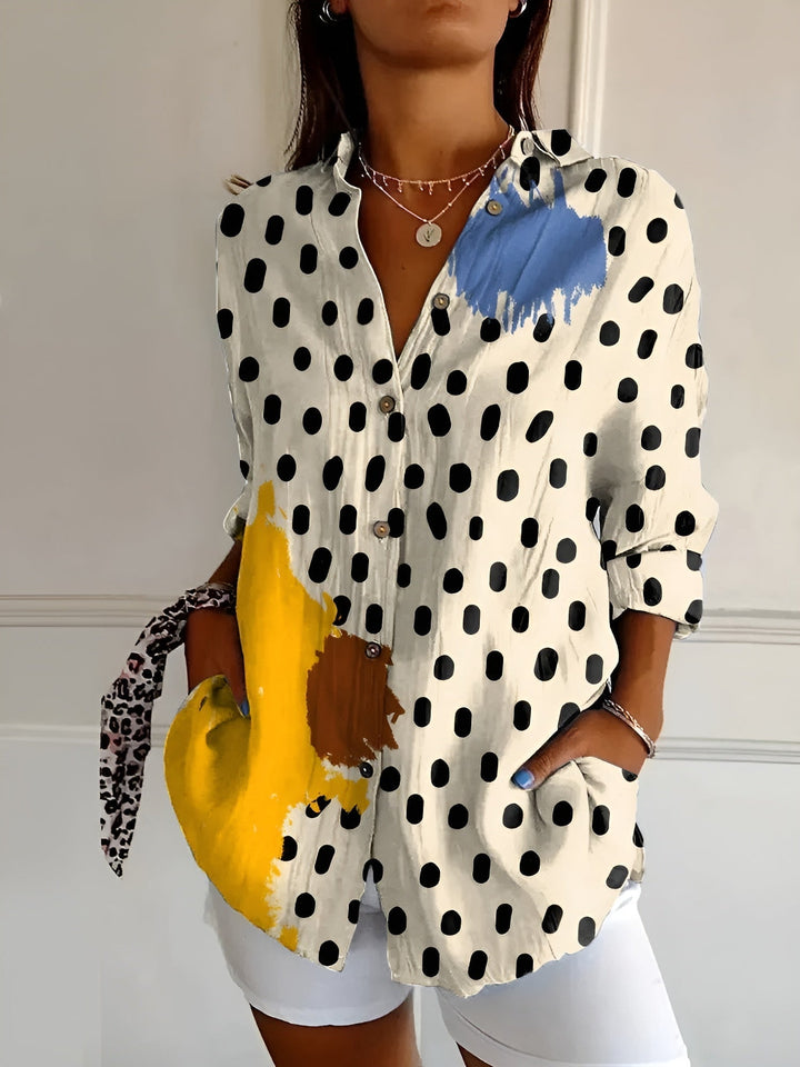 Vibrant women's patterned blouse, button-front, with three-quarter rolled sleeves. Perfect for elegant spring wear.
