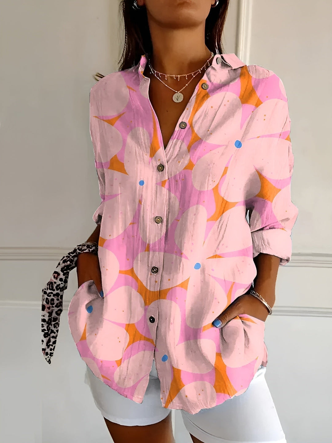Fashionable women's printed top with a button-front design & rolled three-quarter sleeves. Summer style.
