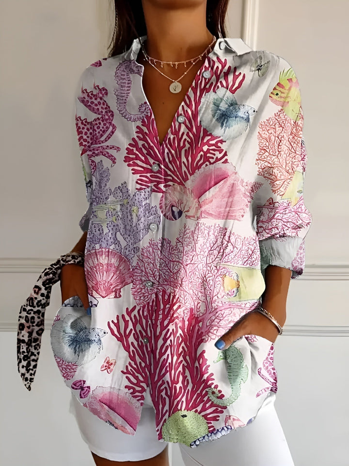 Elegant women's collared blouse featuring a vibrant print & button-front. Rolled 3/4 sleeves, perfect for summer.