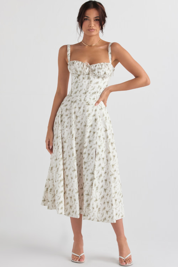 Close-up of the elegant floral print on a women's chic white corset midi dress. Evening fashion.