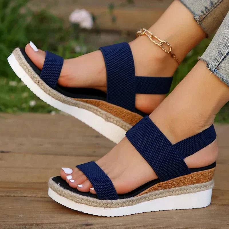 Women's feet wearing comfortable adaptive platform sandals with stretch straps, perfect for walking.