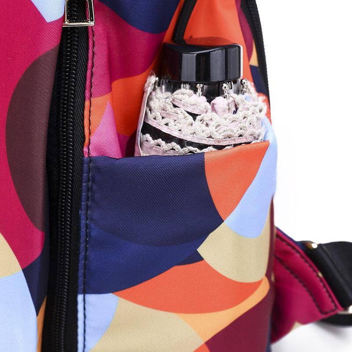 Woman walking with a black water-resistant anti-theft backpack, perfect daily bag for secure city travel.