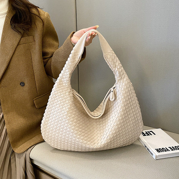 Close-up of bohemian braided hobo bag, showcasing intricate woven leather texture and craftsmanship.