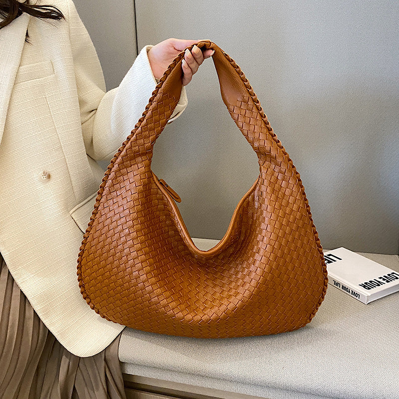 Stylish woman wearing a bohemian braided hobo bag as a shoulder bag, ideal casual everyday accessory.