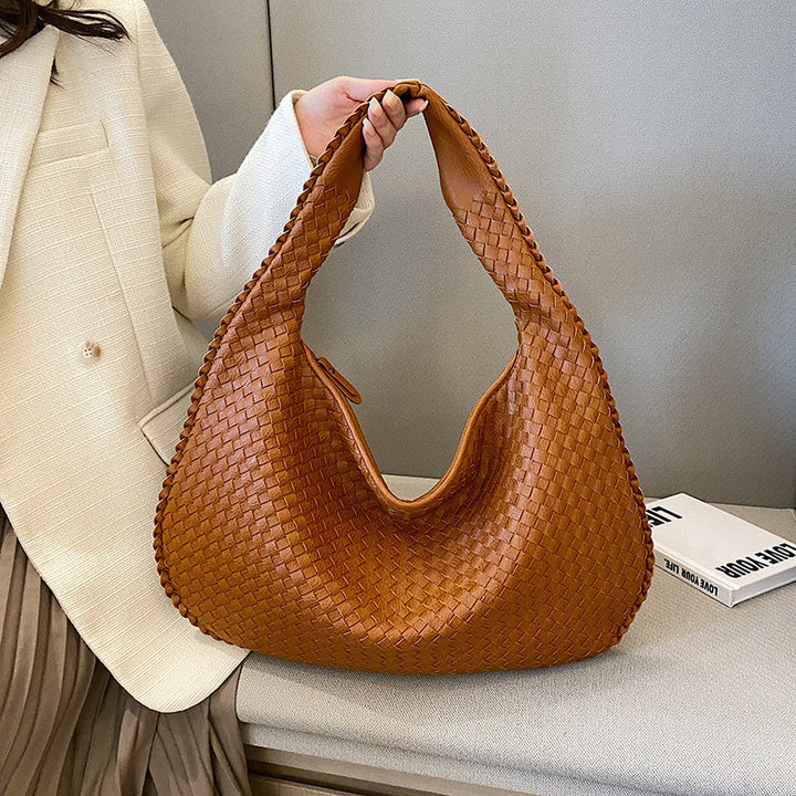 Stylish woman wearing a bohemian braided hobo bag as a shoulder bag, ideal casual everyday accessory.