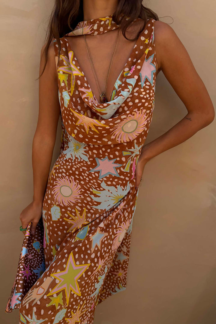 Full shot of a woman wearing a brown fawn print halter maxi dress, front view, resort wear.