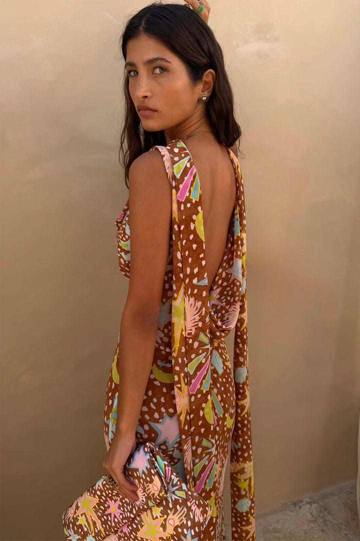Side view highlighting the elegant bias cut of the brown fawn print cowl neck halter maxi dress.