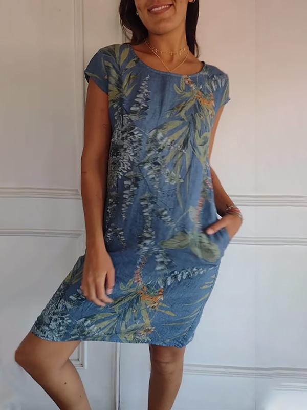 V-neck women's casual summer dress in a midi length, adorned with a tropical leaf print and useful pockets.