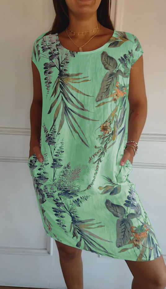 Women's warm weather midi dress with a fresh leaf print, short sleeves, and handy pockets for a casual look.
