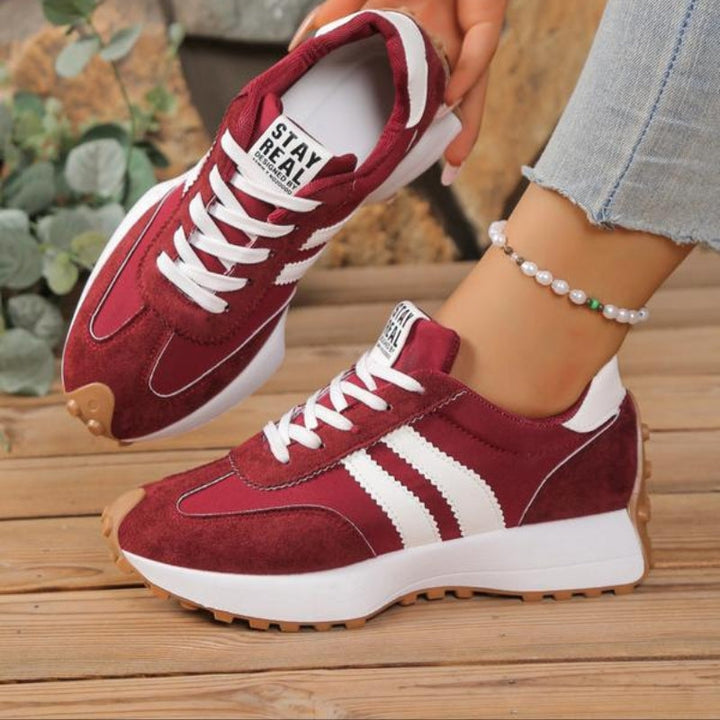 Side profile of women's retro chic trainers, highlighting stylish lace-up details and comfort.